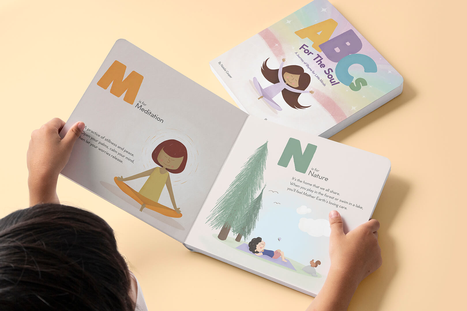 A child holds ABCs for the Soul open to M is for Meditation and N is for Nature