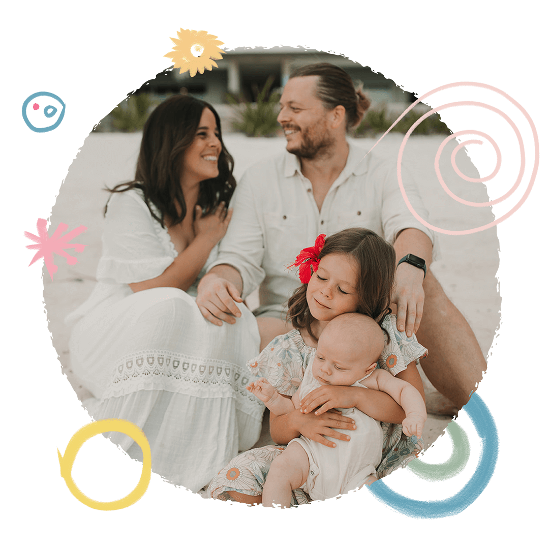 Natalie and Adrian Cooper sitting outdoors with their two young children