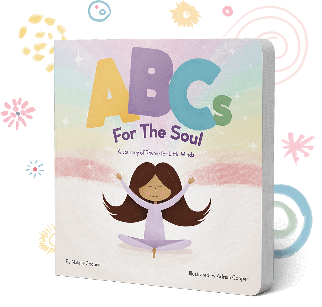 The cover of ABCs for the Soul: a smiling girl sits cross-legged with her arms raised in front of a soft pastel rainbow